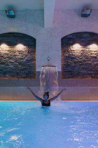 泽勒兹纳·鲁达OREA Resort Horizont Šumava的瀑布游泳池中的女人