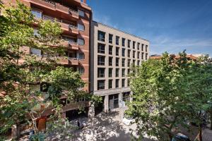 巴塞罗那拿波尔斯公寓式酒店的前面有树木的高大的砖砌建筑