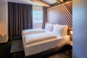 美因河畔法兰克福B&B HOTEL Frankfurt-Niederrad的酒店客房设有床和窗户。