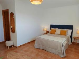 普埃尔托明加尔沃Habitaciones Mirall Rural的一间卧室配有带橙色枕头的床