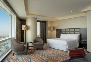 科威特福朋喜来登酒店的酒店客房带床、椅子和窗户