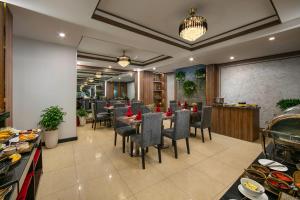 河内Hanoi La Palm Premier Hotel & Spa的餐厅设有1间带桌椅的用餐室