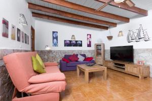 TriquivijateHome2Book Villa Guayarmina, Private Pool的带沙发和电视的客厅