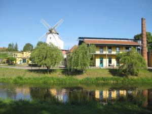 Bad SülzeDoppelzimmer 13 Gästehaus Mühlenstein的风车和河边的房子