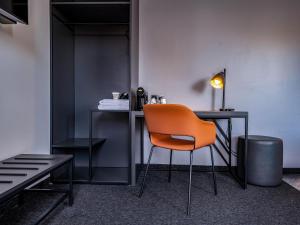 菲林根-施文宁根B&B Hotel Villingen-Schwenningen的坐在一张桌子上的橙色椅子