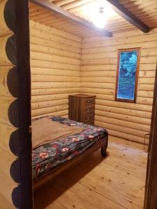 安布罗劳里Cottage Sochi的小木屋内一间卧室,配有一张床