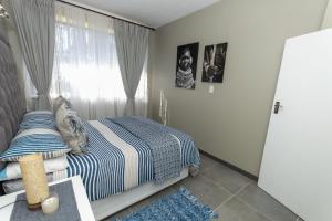 比勒陀利亚AfricaLove on Tiger的一间卧室设有一张床和一个窗口