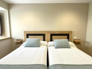 贝加德奥Apartamentos Casa Courego的配有两张床铺的客房配有两张枕头