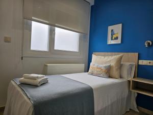圣地亚哥－德孔波斯特拉Inicia AVIO Apartamentos的蓝色卧室,配有带毛巾的床