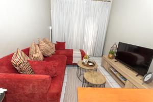 比勒陀利亚AfricaLove on Tiger的客厅配有红色沙发和电视
