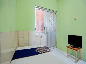 泗水OYO Life 92653 Homestay Griya Nautika Syariah的小房间设有床和电视