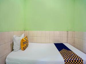 泗水OYO Life 92653 Homestay Griya Nautika Syariah的一张位于房间的床,上面有两个枕头