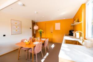 栋堡Residenties en bungalow Royal Domburg的一间拥有橙色墙壁和桌椅的用餐室
