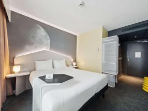 鲁瓦西昂法兰西宜必思尚品巴黎戴高乐机场酒店的一间卧室配有一张大床,墙上涂有月亮。