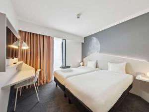 鲁瓦西昂法兰西宜必思尚品巴黎戴高乐机场酒店的酒店客房配有两张床和一张书桌