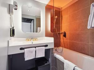 鲁瓦西昂法兰西宜必思尚品巴黎戴高乐机场酒店的一间带水槽、浴缸和镜子的浴室