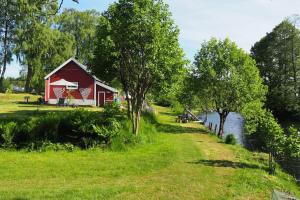 VegårsheiRiverside Bliss Idyllic Camp, 3 Man Tent Incl, near Tvedestrand and Arendal的河岸边的红谷仓