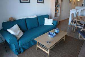 内尔哈JARDINES DE NERJA 18 MENYBER的客厅配有一张蓝色的沙发,配有一张桌子