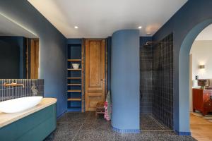 海牙拉波罗瓦住宿加早餐旅馆的浴室配有蓝色的墙壁、浴缸和水槽。