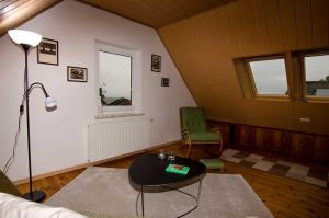 洛默Ferienhaus Luette_的客厅配有桌子和台灯