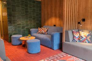 别拉什尼察Hotel Nomad的客厅配有2把蓝色椅子和桌子