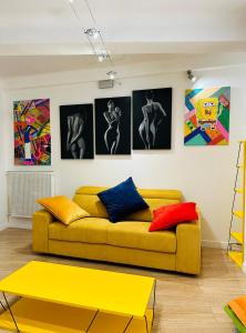 阿维尼翁POP appART Appartement Artiste 200 m du centre ville Parking privé gratuit的客厅配有黄色沙发和墙上的照片