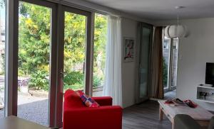 佐伊杜比斯特HOME for 2的客厅设有红色椅子和大窗户