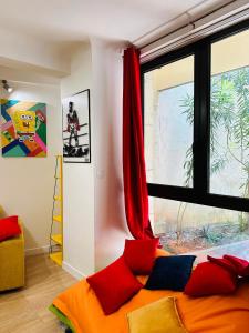 阿维尼翁POP appART Appartement Artiste 200 m du centre ville Parking privé gratuit的一间卧室配有一张带红色和蓝色枕头的床