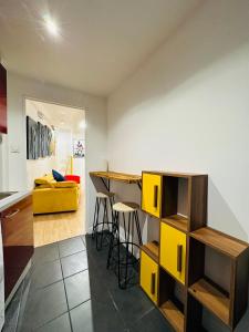 阿维尼翁POP appART Appartement Artiste 200 m du centre ville Parking privé gratuit的厨房以及带黄色橱柜和柜台的起居室。