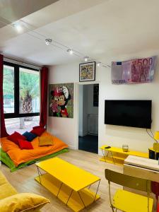 阿维尼翁POP appART Appartement Artiste 200 m du centre ville Parking privé gratuit的客厅配有黄色和橙色家具以及平面电视。