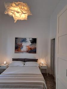 曼杜里亚Civico 2的卧室配有一张床,墙上挂有绘画作品