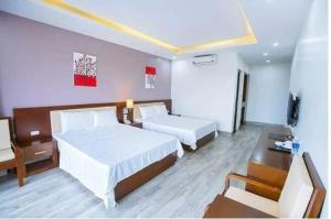 岑山Sen Biển Hotel FLC Sầm Sơn的酒店客房配有两张床和一张书桌