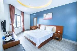 岑山Sen Biển Hotel FLC Sầm Sơn的一间卧室设有一张大床和蓝色的墙壁