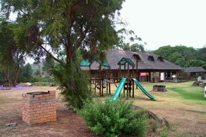 PaulpietersburgGooderson Leisure Natal Spa Self Catering and Timeshare Resort的一座有树的建筑前的游乐场