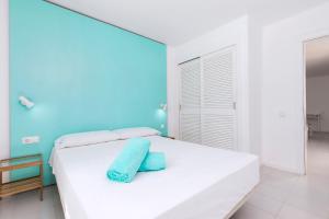 卡勒达德福斯特Smy Tahona Fuerteventura的蓝色墙壁的房间里一张白色的床
