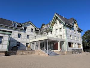 芙露姆赛山居会弗鲁姆赛堡酒店的一座白色的大建筑,前面有楼梯