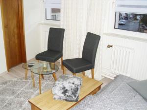 DwasiedenFerienzimmer Am Stadtrand的客厅配有两把椅子和一张玻璃桌