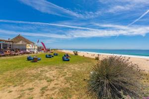 塔里法Chalet en la playa de Bolonia的一群人坐在海滩附近的草地上