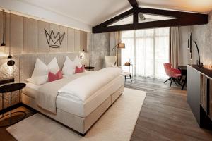 塞尔瓦迪加尔代纳山谷The Laurin Small & Charming的卧室配有带红色枕头的大型白色床