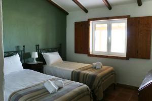 Vale de ÁguaMonte da Casa Nova - Jul and Ago only 7 days stays check-in and check-out on Saturdays的一间卧室设有两张床和窗户。