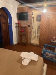 舍夫沙万Riad Mauritania的一间卧室配有一张床、一台电视和毛巾