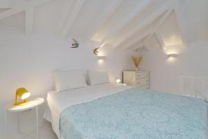 伊兹拉Gaia accomodation Hydras的白色卧室配有一张带蓝色毯子的床