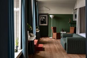 切尔滕纳姆Cowley Manor Experimental的客厅设有绿色的墙壁和蓝色的沙发