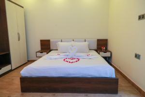 斯里曼加尔乌帕齐拉Balishira Resort Ltd.的卧室配有白色的床,上面有弓
