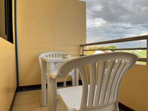 塔里萨伊HRS APARTELLE的阳台配有2把白色椅子和桌子