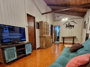 伊瓜苏港La Casa Del Lago URUGUA-Í的客厅配有电视和蓝色沙发。