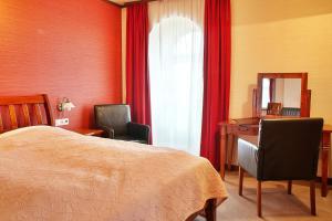 扎泰茨扎泰茨兹莱提列弗酒店的一间卧室配有一张床、一张书桌和一面镜子