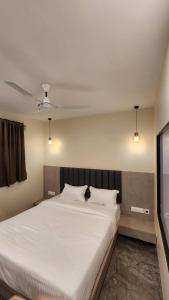 孟买Peace International的卧室配有一张带两个枕头的大白色床