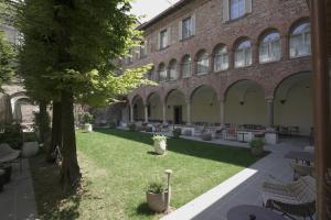 贝加莫Palazzo Santo Spirito的建筑前方的庭院配有桌椅