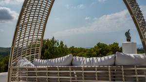 圣安东尼奥Can Paradís的庭院内带白色枕头的藤椅